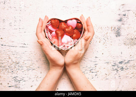 Le mani della donna Valentino cupping confezione regalo Foto Stock