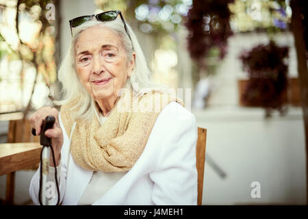 Ritratto di sorridente caucasici più vecchi donna che indossa una sciarpa Foto Stock