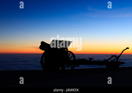 Silhouette di cannone al crepuscolo. Paesaggio notturno dalle Alpi italiane. Foto Stock