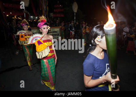 Le ragazze di Bali portando torce fiammeggianti durante il corteo cerimoniale presso la parata Ngrupuk Balinese per Capodanno. La Street Parade di cultura Balinese Foto Stock