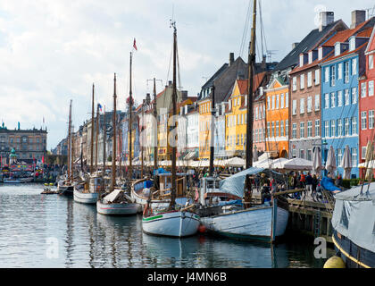 Molo di nyhavn nel centro di copenhagen, Danimarca. i turisti e i locali godono la colorata architettura, bar, ristoranti e barche. Foto Stock