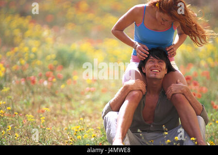 Flower meadow, uomo a gambe incrociate, donna, spalle, sedersi, contatto visivo matura, giovane, cade nell'amore, felicemente, divertente, prato prato estivo, fuori stagione, estate, di amore, di affetto, di godere, stare insieme, sorriso, felicemente Foto Stock