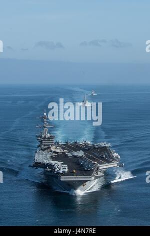 Gli Stati Uniti Nimitz Navy-class portaerei nucleare USS Theodore Roosevelt sotto scorta da parte di navi e di aeromobili durante un esercizio di formazione Maggio 11, 2017 nell'Oceano Pacifico. Foto Stock