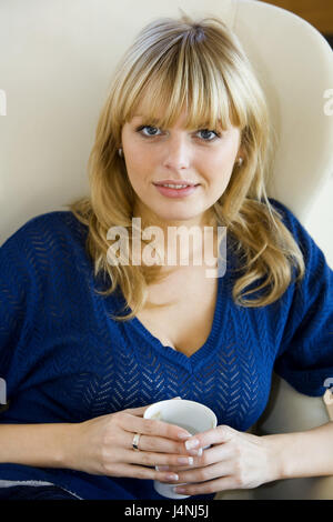 Donna, giovane, poltrone, sedersi, tenere bere mug, ritratto, Foto Stock