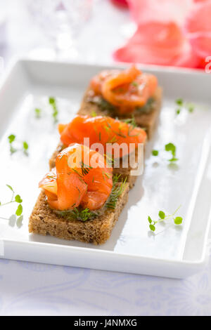 Deliziosi antipasti crostini di pane nero con salmone affumicato per le vacanze Foto Stock