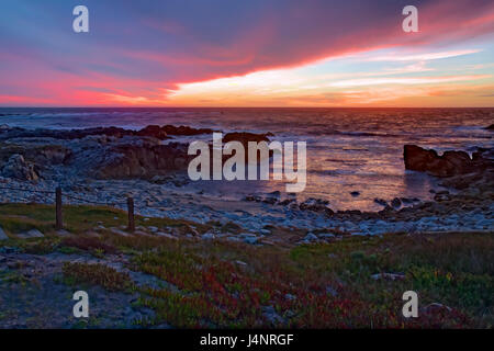 Immagine hdr di drammatiche nuvole al tramonto sulla sabbia e rocce di Asilomar membro Beach in Pacific Grove sulla penisola di Monterey in California Foto Stock