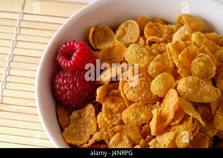 Ciotola di cereale con lamponi closeup sul tappetino di bambù Foto Stock