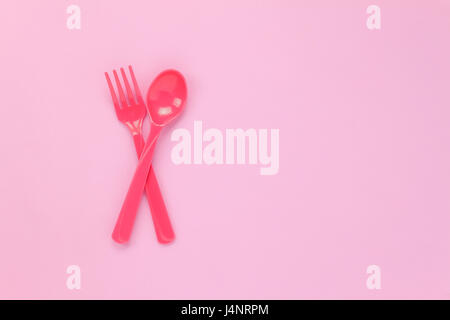 Vista superiore in plastica colorata cucchiaio rosa su sfondo tabella con copia spazio. Foto Stock