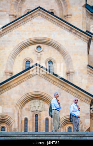 Due blu imprenditori shirted stand al top delle fasi di Sameba o la Cattedrale della Trinità di Tbilisi nella capitale georgiana. Foto Stock