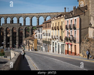 Una vista romano di Segovia Mirador acquedotto arcate doppie dal lato con la fila di colorato colorato case della città di San Juan e pedoni, Spagna Foto Stock