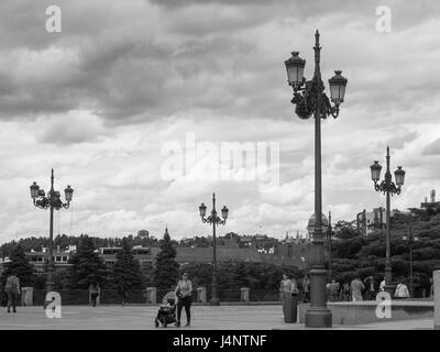 Un bianco e nero vista Street light luci lampade lamposts perforare il cielo nuvoloso il Jardines del Cabo Noval al di fuori del Palacio Real Foto Stock