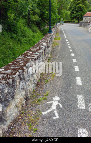 Uomo che cammina, sentiero lungo la strada, Francia Foto Stock