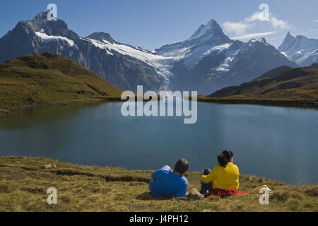 Lago di montagna, panorama alpino, giovane, sedersi, vista posteriore, picnic, prateria alpina, consumo, scenario, guardare, Svizzera, le alpi Bernesi, Grindelwald, Brook Alpsee, nessun modello di rilascio, Foto Stock