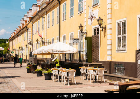 Riga, Lettonia - 2 Luglio 2, 2016: Street Cafe Ristorante In Città Vecchia sotto le facciate del vecchio famoso Jacob caserma torna sulla strada. La caserma sono stati costruiti Foto Stock