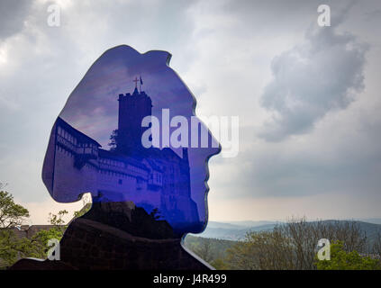 Eisenach, Germania. 9 maggio 2017. Il castello di Wartburg si riflette in un'immagine di Martin Lutero pubblicità una mostra a Eisenach, Germania, 9 maggio 2017. Uno dei momenti salienti della celebrazione del V centenario della riforma è la apertura del modo di Lutero ("Lutherweg') 1521 tra Eisenach e worm di Domenica, 14 maggio 2017. L'circa 400 km lungo il percorso di pellegrinaggio è detto per attirare gli escursionisti e turisti. Foto: Frank Rumpenhorst/dpa/Alamy Live News Foto Stock