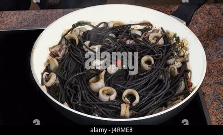 Cucina pasta nera con calamari (seppie) e l'inchiostro Foto Stock