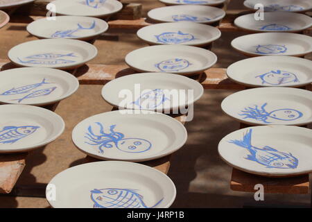 Spagnolo le piastre in ceramica con pesce azzurro disegni su sfondo bianco essiccazione su rack Sun Foto Stock