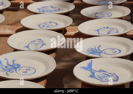 Spagnolo le piastre in ceramica con pesce azzurro disegni su sfondo bianco essiccazione su rack Sun Foto Stock