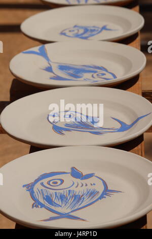 Spagnolo le piastre in ceramica con pesce azzurro disegni su sfondo bianco essiccazione su rack Sun Foto Stock