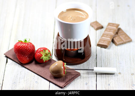 La Fonduta di cioccolato con fragole su sfondo di legno Foto Stock