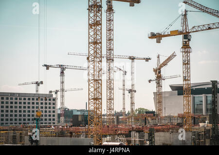 Molte gru e lavoratori edili sulla grande sito in costruzione Foto Stock