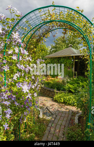 Vista su casa giardino verde con pergolato a giornata di sole Foto Stock