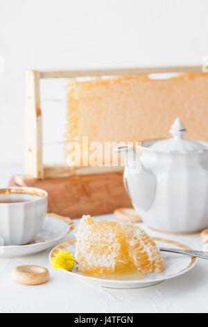 Tazze di tè con il nido e bagel su sfondo bianco Foto Stock