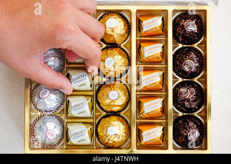 Paphos, Cipro - 20 novembre 2016 Donna mano tenendo la caramella Ferrero teneramente da scatola di caramelle Ferrero. Foto Stock