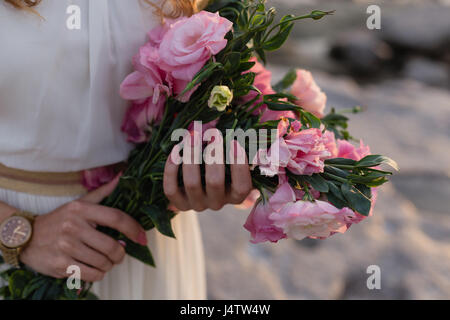 Donna mani bouquet di rosa eustoma Foto Stock