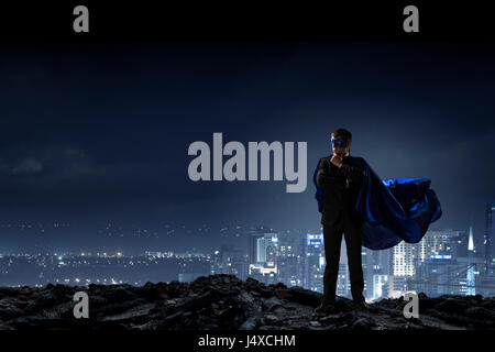 Giovani fiduciosi super imprenditore della maschera e mantello. I supporti misti Foto Stock