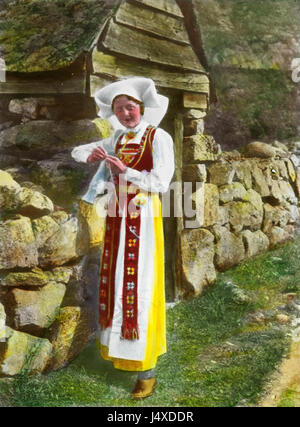 Questa fotografia, datata intorno al 1915, raffigura una donna che indossa il tradizionale costume nazionale norvegese. L'immagine riflette l'abbigliamento, i costumi e l'identità nazionale della Norvegia durante l'inizio del XX secolo. Foto Stock