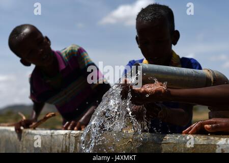 Bambini lavare con acqua da una pipeline nel villaggio di Afraaga, il Somaliland dove la carità CARE International hanno costruito un serbatoio di stoccaggio e installato gli oleodotti e i rubinetti a dare gli abitanti di un villaggio di accesso all acqua pulita da un foro di trivellazione nelle vicinanze. Foto Stock