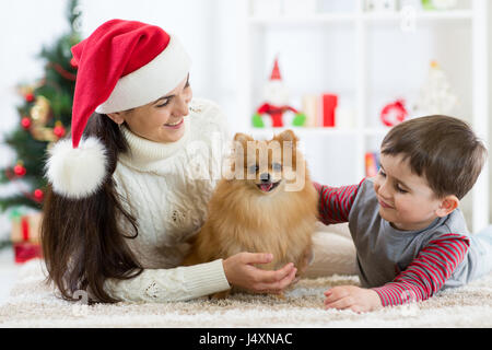 Natale felice famiglia della madre e suo figlio bambino e cane spitz Foto Stock