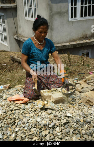 La donna la frantumazione di rocce con un martello per la costruzione di strade,Rinchenpung, Sikkim, Indiia Foto Stock