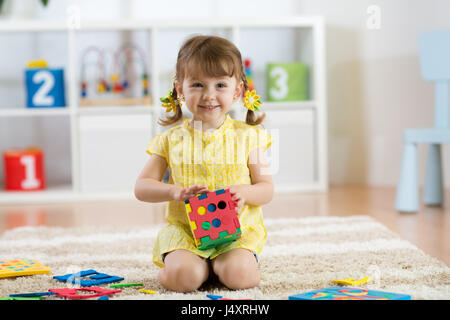 Bambino preschooler bambina gioca giocattolo logico imparare forme e colori a casa o stanza dei bambini Foto Stock