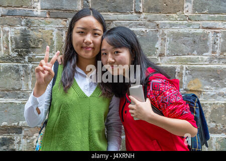 Zhenyuan, Guizhou, Cina. Due giovani donne che posano per una foto. Foto Stock