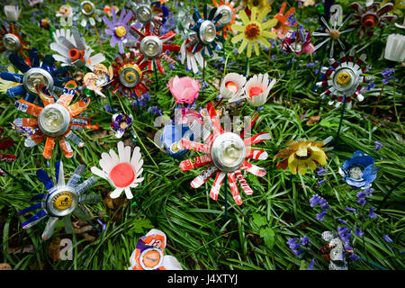 È sotto embargo per 0001 Lunedì 15 Maggio fiori riciclata con lettiera per artista Michelle Reader, sedersi tra decine piantata sul suolo della foresta come parte di una installazione artistica nella Foresta di Dean, Gloucestershire, per accrescere la consapevolezza della lettiera rurale problemi nella zona. Foto Stock