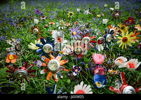 È sotto embargo per 0001 Lunedì 15 Maggio fiori riciclata con lettiera per artista Michelle Reader siede tra decine piantata sul suolo della foresta come parte di una installazione artistica nella Foresta di Dean, Gloucestershire, per accrescere la consapevolezza della lettiera rurale problemi nella zona. Foto Stock