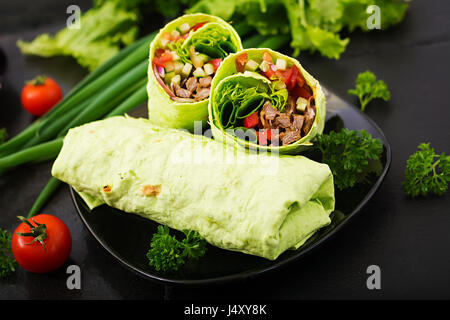 Shawarma da succosa carne di manzo, lattuga, pomodori, cetrioli, la paprika e la cipolla nel pane pita con spinaci. Menù dietetici Foto Stock