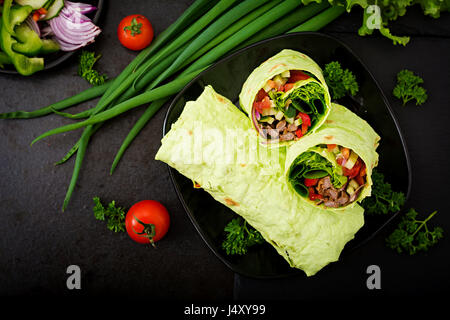 Shawarma da succosa carne di manzo, lattuga, pomodori, cetrioli, la paprika e la cipolla nel pane pita con spinaci. Menù dietetici Foto Stock