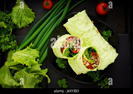 Shawarma da succosa carne di manzo, lattuga, pomodori, cetrioli, la paprika e la cipolla nel pane pita con spinaci. Menù dietetici Foto Stock