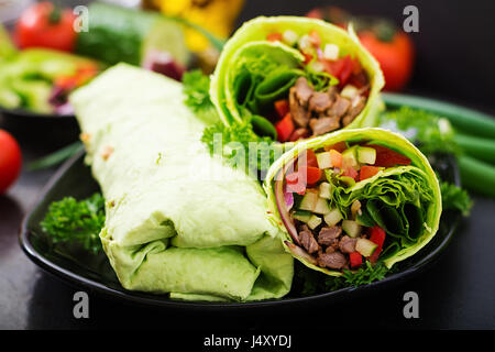 Shawarma da succosa carne di manzo, lattuga, pomodori, cetrioli, la paprika e la cipolla nel pane pita con spinaci. Menù dietetici Foto Stock