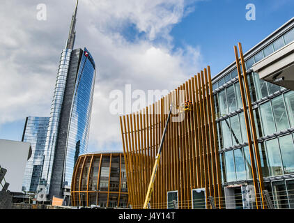 Un paio di lavoratori, lavorando su piattaforma aerea per una nuova costruzione nei pressi di Torre di unicredit a Milano centro Foto Stock