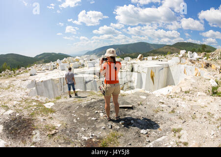 I turisti sono fotografati nel vecchio abbandonato cava di marmo. Foto Stock