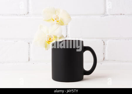 Nero caffè mug mockup con soft orchidea gialla. Boccale vuoto mock up per la promozione del brand. Foto Stock