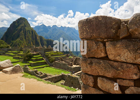 Stone muro di mattoni in fondo sfocato di Machu Picchu. Messa a fuoco selezionata sul muro di pietra a Machu Picchu Foto Stock