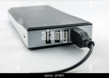 Nero Powerbank con collegato il cavo isolato su sfondo bianco Foto Stock