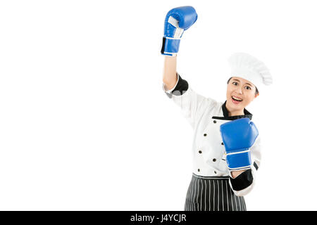 Premiato chef donna celebrando indossa guantoni da pugilato e costume di cottura. Il vincitore e lo chef cucinare il concetto di successo foto di giovani multirazziale chef asiatico w Foto Stock