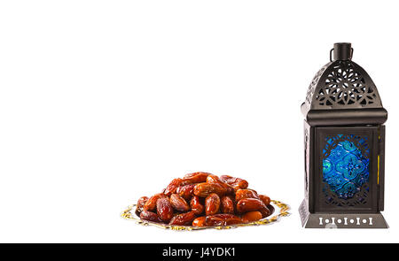 Splendido splendente Fanus lanterna e datteri secchi su un vassoio d'argento isolamento su sfondo bianco. La festa islamica del mese sacro del Ramadan Kareem Foto Stock