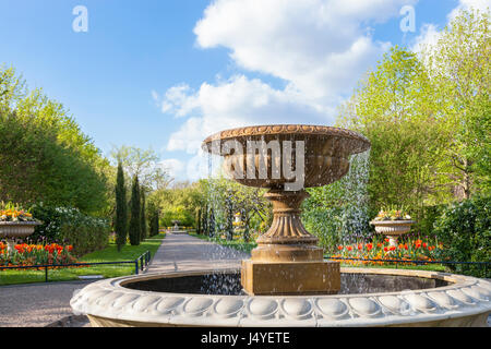 Alberi, fiori e una fontana in Avenue Giardini a Regents Park, Londra, uno dei parchi reali. London, England, Regno Unito Foto Stock